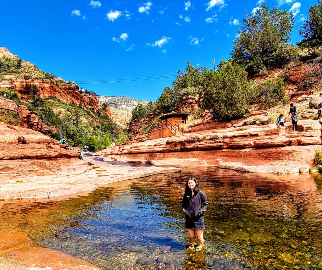 Woman stands in the wadding pool at The Slide Rock State Park In Sedona, Arizona.
